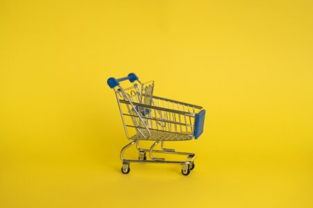 Un mini-caddie de supermarché sur un fond jaune